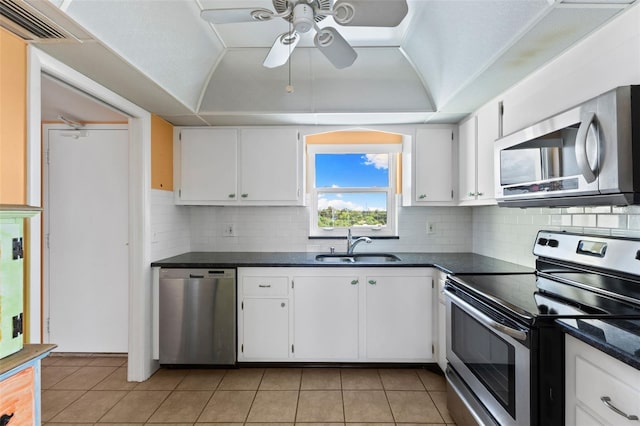 kitchen featuring white cabinets, ceiling fan, stainless steel appliances, and decorative backsplash