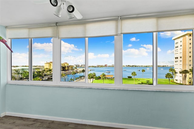 unfurnished sunroom featuring a water view and ceiling fan