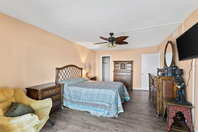 bedroom featuring baseboards, wood finished floors, visible vents, and ceiling fan