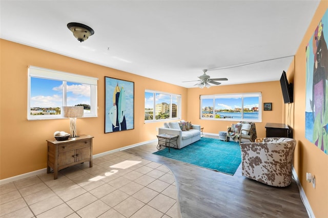 living area with ceiling fan, baseboards, and wood finished floors