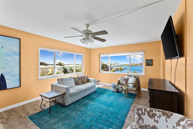 living area with ceiling fan, baseboards, and wood finished floors