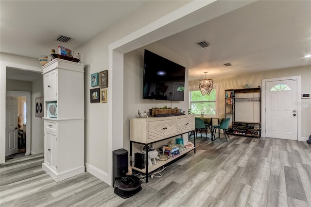 living room with light hardwood / wood-style flooring and a notable chandelier