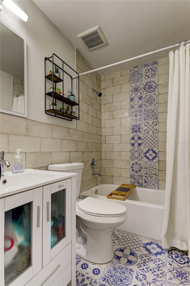 full bathroom featuring toilet, tile patterned floors, vanity, tile walls, and shower / tub combo with curtain