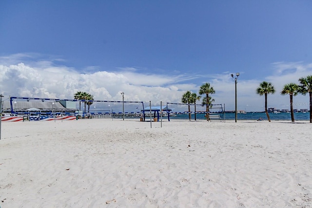 view of property's community featuring a water view, volleyball court, and a view of the beach