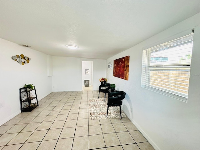 living area featuring a textured ceiling and light tile patterned flooring