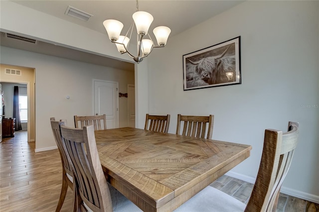 dining area featuring a notable chandelier and hardwood / wood-style flooring