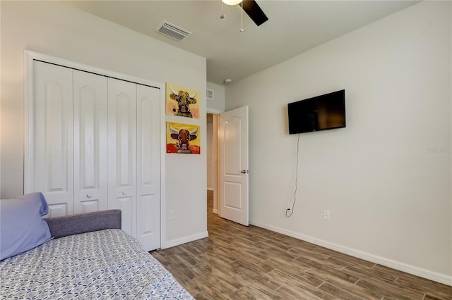 bedroom with hardwood / wood-style flooring, a closet, and ceiling fan