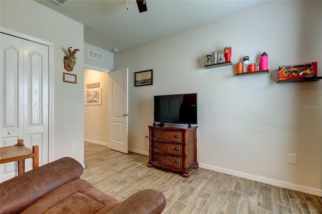 living room featuring light wood-type flooring and ceiling fan