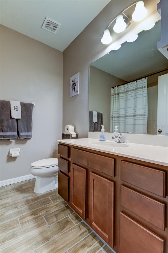 bathroom featuring vanity, toilet, and wood-type flooring