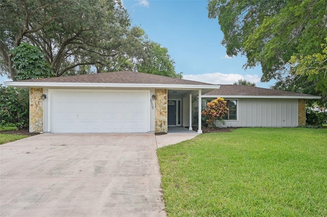 single story home featuring a front yard, a garage, and driveway