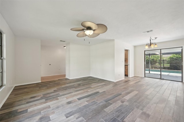 unfurnished room with ceiling fan with notable chandelier and wood-type flooring