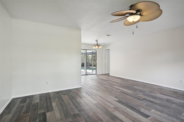 unfurnished room with ceiling fan with notable chandelier and dark wood-type flooring