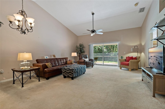 carpeted living room featuring ceiling fan with notable chandelier and high vaulted ceiling