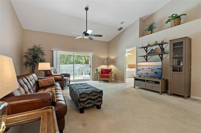 carpeted living room with ceiling fan and high vaulted ceiling