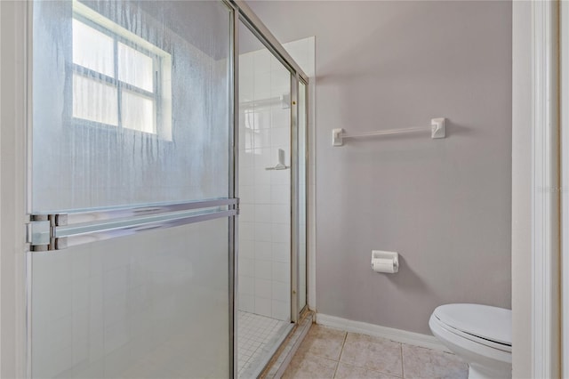 bathroom with toilet, a shower with door, and tile patterned floors