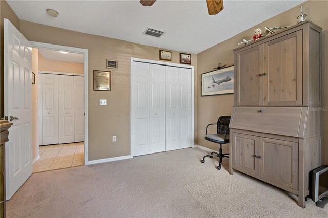 carpeted office space featuring ceiling fan