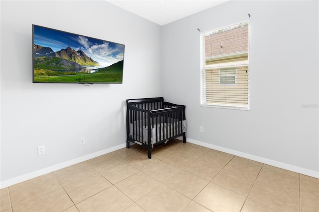 bedroom featuring light tile patterned floors and a nursery area