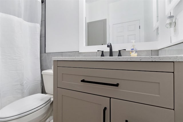 bathroom with vanity, toilet, tile walls, and backsplash