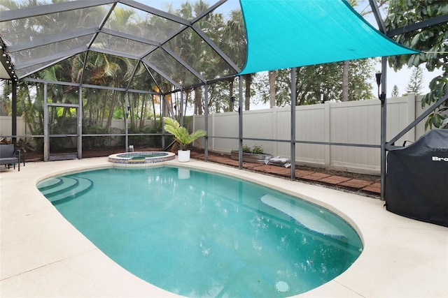 view of pool with an in ground hot tub, area for grilling, a patio, and glass enclosure