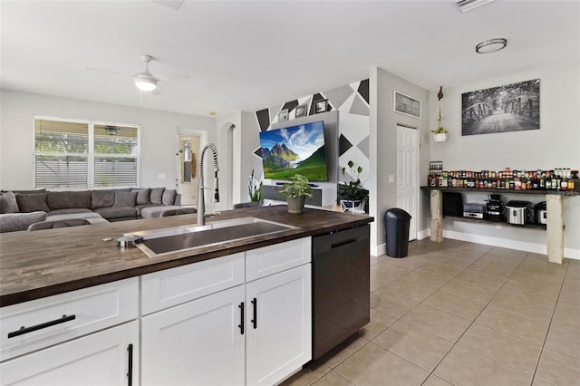 kitchen with dishwasher, sink, ceiling fan, light tile patterned floors, and white cabinetry