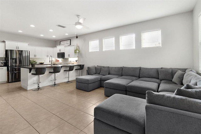 living room featuring sink, ceiling fan, a healthy amount of sunlight, and light tile patterned flooring