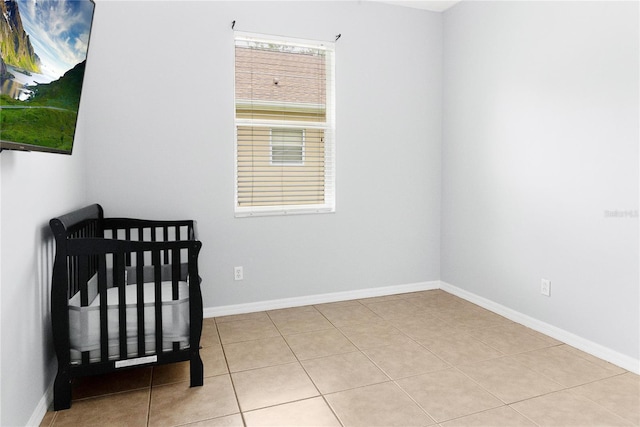 bedroom with light tile patterned flooring and a crib