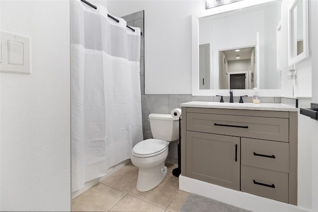 bathroom featuring tile patterned flooring, vanity, toilet, and walk in shower