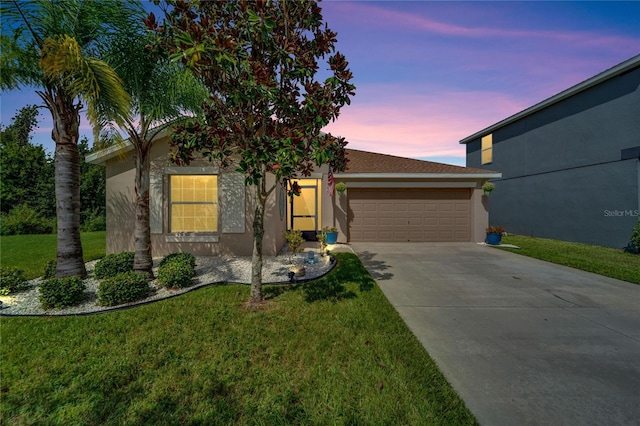 view of front of home featuring a garage and a yard