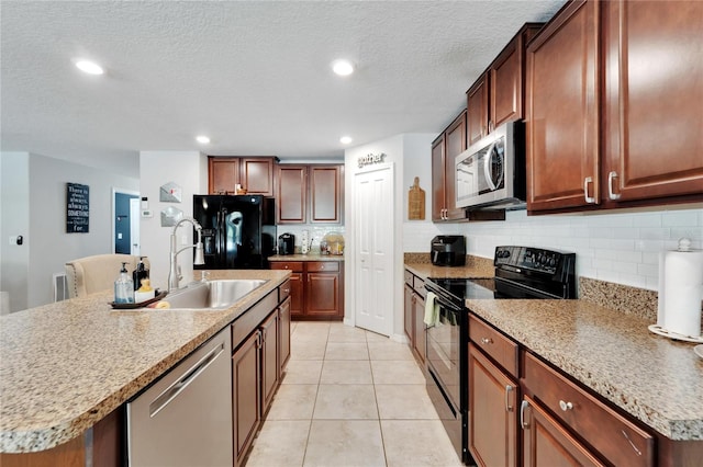 kitchen with black appliances, an island with sink, tasteful backsplash, and sink