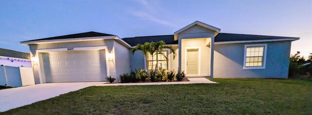 view of front of home with a yard and a garage