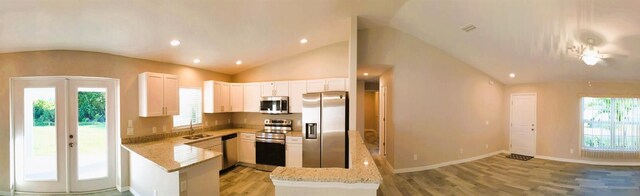 kitchen with appliances with stainless steel finishes, white cabinetry, light hardwood / wood-style flooring, and french doors