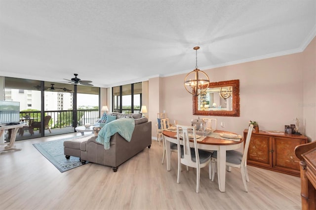 dining room with light hardwood / wood-style flooring, ceiling fan with notable chandelier, expansive windows, ornamental molding, and a textured ceiling