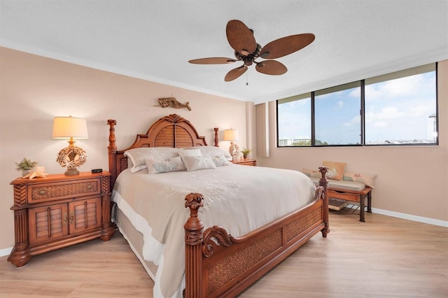 bedroom with ceiling fan, ornamental molding, and light hardwood / wood-style flooring