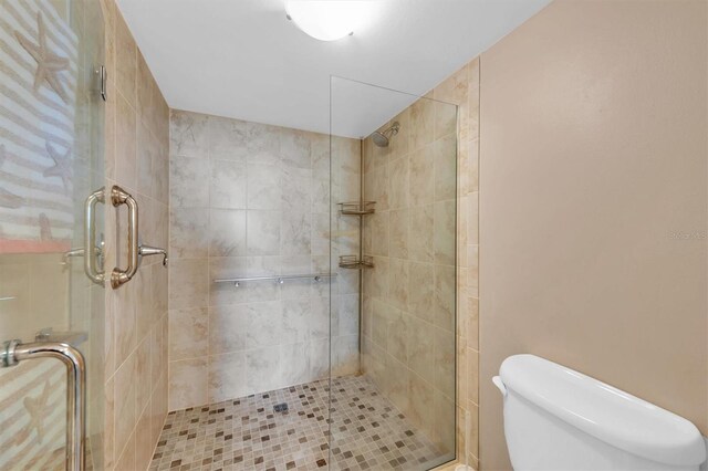 bathroom featuring walk in shower and toilet