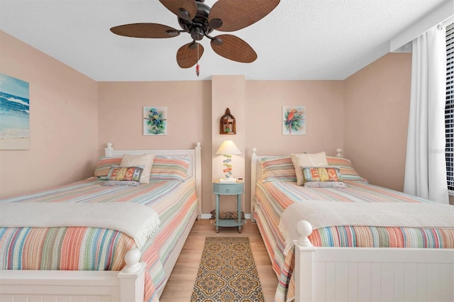 bedroom featuring a textured ceiling, ceiling fan, and light hardwood / wood-style floors