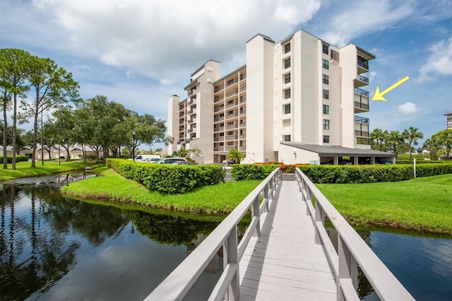 view of dock featuring a balcony, a yard, and a water view