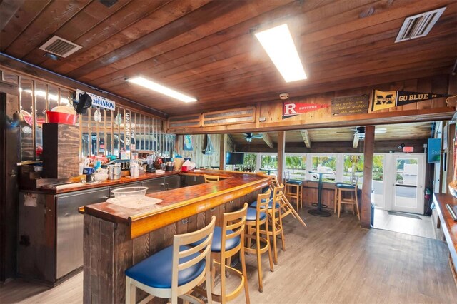 bar with wooden ceiling, hardwood / wood-style flooring, and butcher block countertops