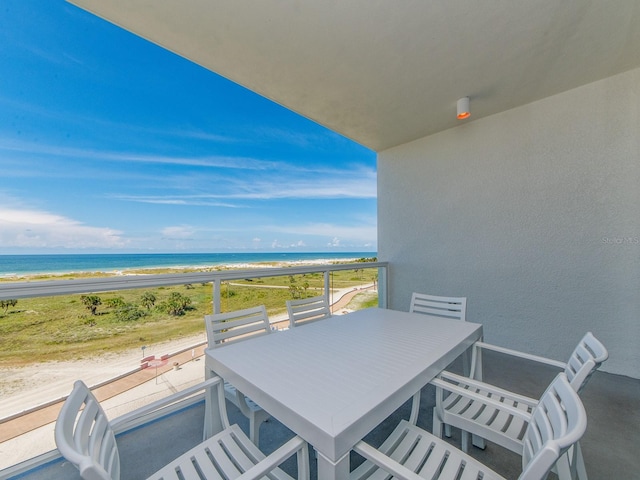 balcony featuring a view of the beach and a water view