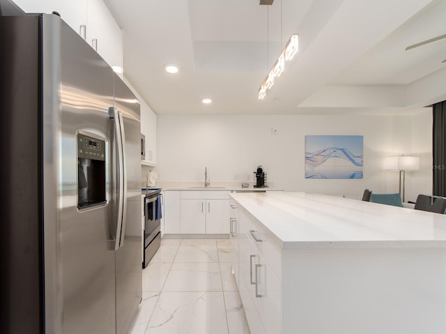 kitchen featuring pendant lighting, stainless steel appliances, white cabinetry, and sink