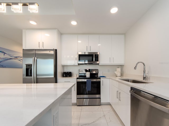 kitchen with stainless steel appliances, sink, and white cabinetry