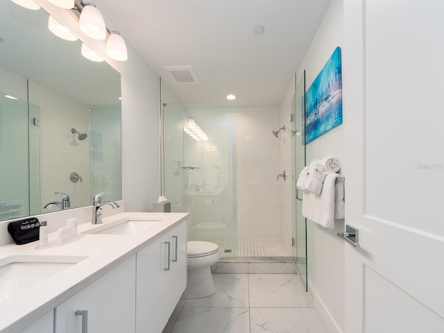 bathroom featuring vanity, toilet, and a shower with shower door