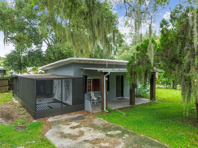 back of property featuring a lawn and a patio area