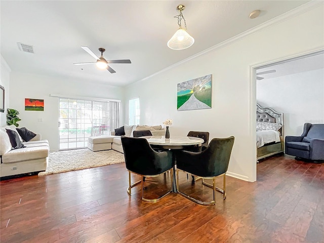 dining space with ornamental molding, ceiling fan, and dark hardwood / wood-style flooring