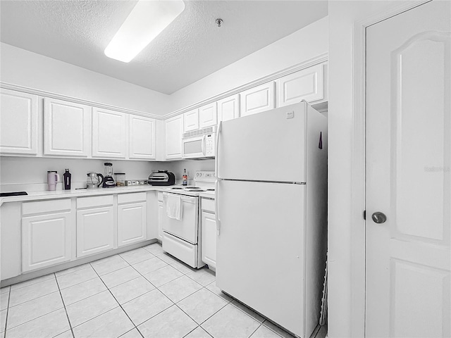 kitchen with a textured ceiling, white appliances, light tile patterned floors, and white cabinets