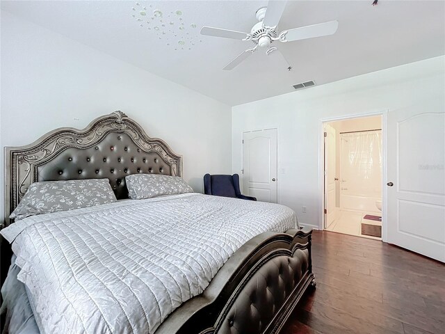 bedroom with ensuite bath, ceiling fan, and dark hardwood / wood-style flooring