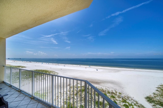 balcony featuring a water view and a beach view