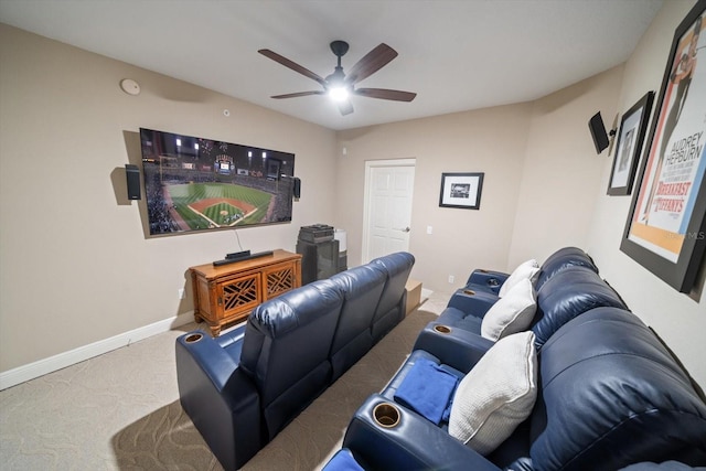 carpeted cinema with a ceiling fan and baseboards