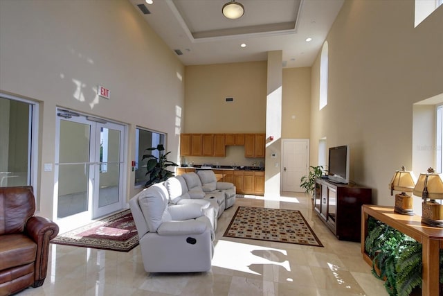 living area featuring a tray ceiling, french doors, visible vents, and recessed lighting