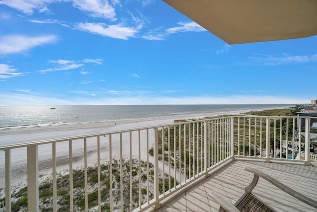 balcony with a water view and a view of the beach