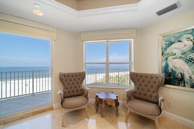 living area with tile patterned flooring, visible vents, a water view, and baseboards